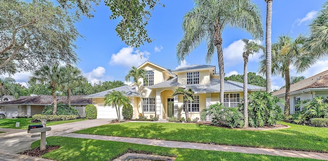 mediterranean / spanish house with a garage and a front yard