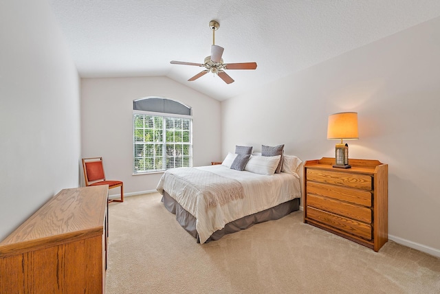 carpeted bedroom with ceiling fan and vaulted ceiling