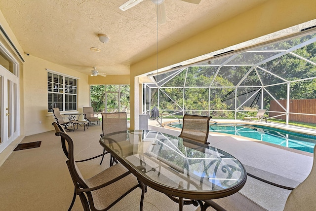 view of patio / terrace featuring ceiling fan, glass enclosure, and a fenced in pool