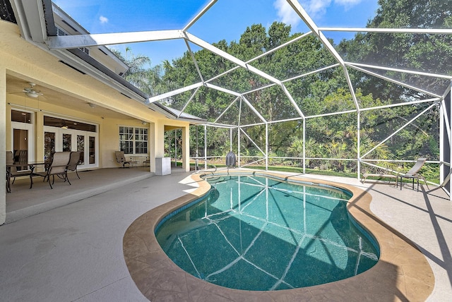 view of pool featuring ceiling fan, a lanai, a patio area, and french doors