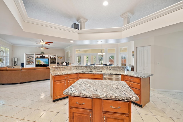 kitchen with ceiling fan with notable chandelier, a center island, light tile patterned flooring, and light stone countertops