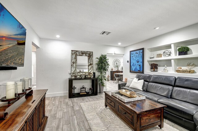 living room featuring a textured ceiling and light hardwood / wood-style floors