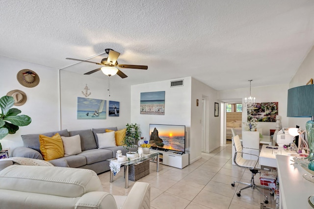 tiled living room featuring ceiling fan with notable chandelier and a textured ceiling