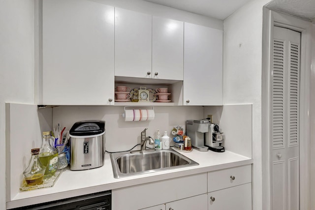 kitchen featuring dishwasher, white cabinetry, and sink