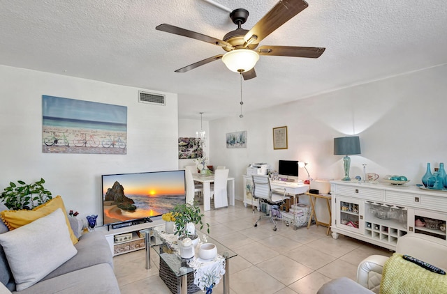 tiled living room with ceiling fan and a textured ceiling