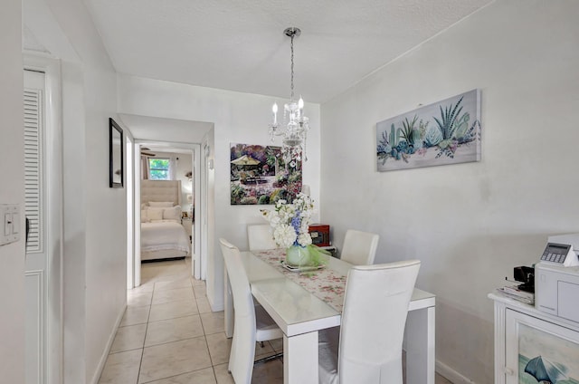 dining area with light tile patterned floors, a notable chandelier, and a textured ceiling