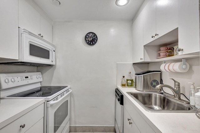 kitchen featuring light tile patterned flooring, white appliances, white cabinetry, and sink