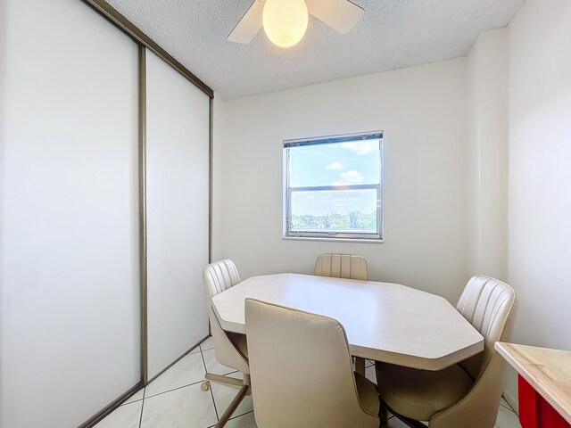 dining area featuring ceiling fan and a textured ceiling