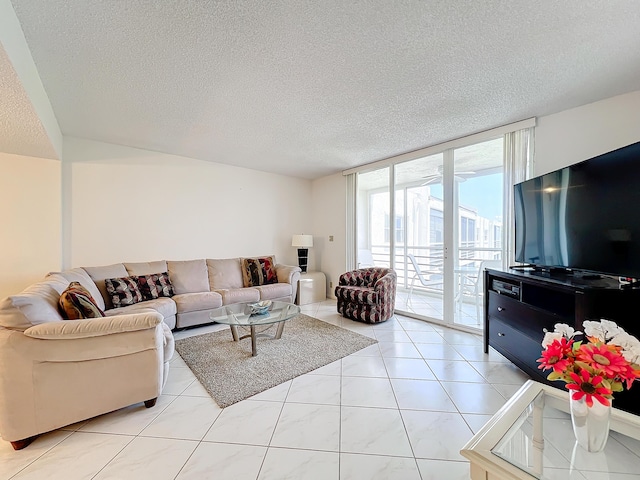 living area featuring expansive windows, a textured ceiling, and light tile patterned floors