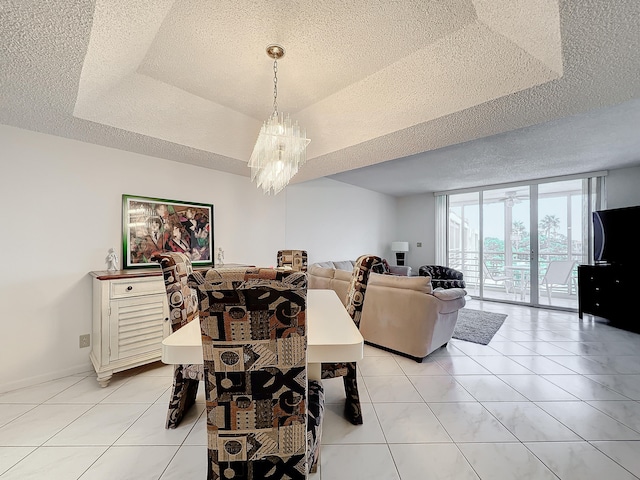 tiled dining space featuring a textured ceiling, floor to ceiling windows, a raised ceiling, and a chandelier