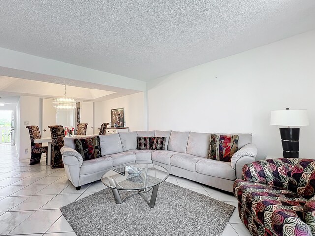 living area with light tile patterned floors, a textured ceiling, and a chandelier