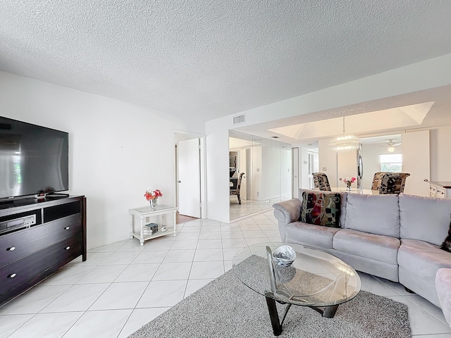 living room featuring light tile patterned floors, visible vents, and a textured ceiling