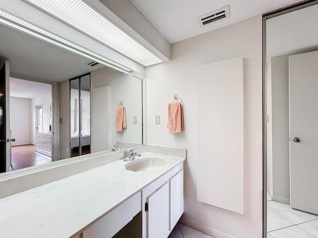 bathroom with tile patterned flooring, visible vents, and vanity