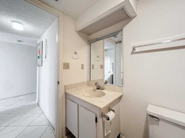 bathroom featuring baseboards, visible vents, toilet, a textured ceiling, and vanity