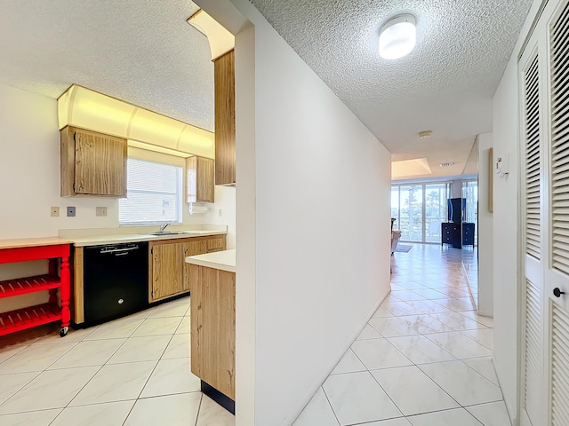 kitchen featuring black dishwasher, light countertops, and light tile patterned floors