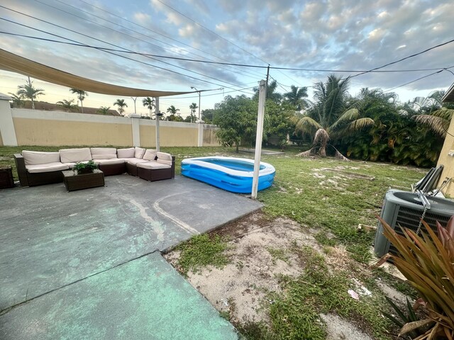 view of yard featuring a patio, an outdoor hangout area, a swimming pool, and central air condition unit