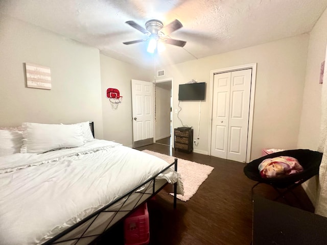 bedroom with ceiling fan, a closet, and dark wood-type flooring