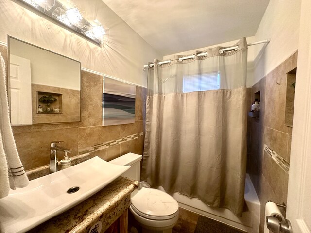 full bathroom with tile walls, vanity, shower / bathtub combination with curtain, and toilet