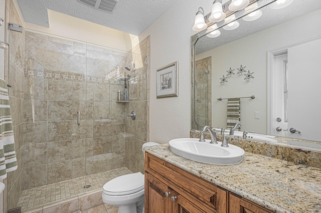 bathroom featuring a textured ceiling, vanity, an enclosed shower, toilet, and tile patterned floors