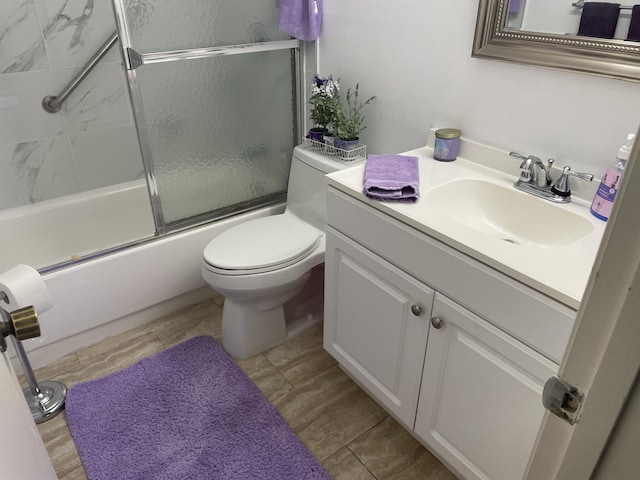 bathroom with shower / bath combination with glass door, vanity, and toilet