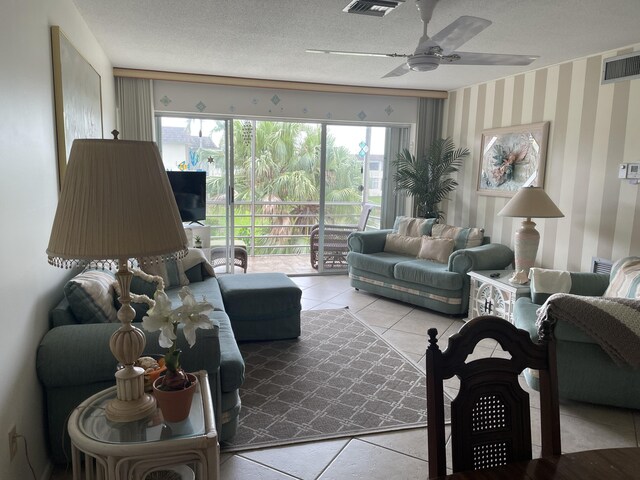 living room with a textured ceiling, light tile patterned flooring, and ceiling fan