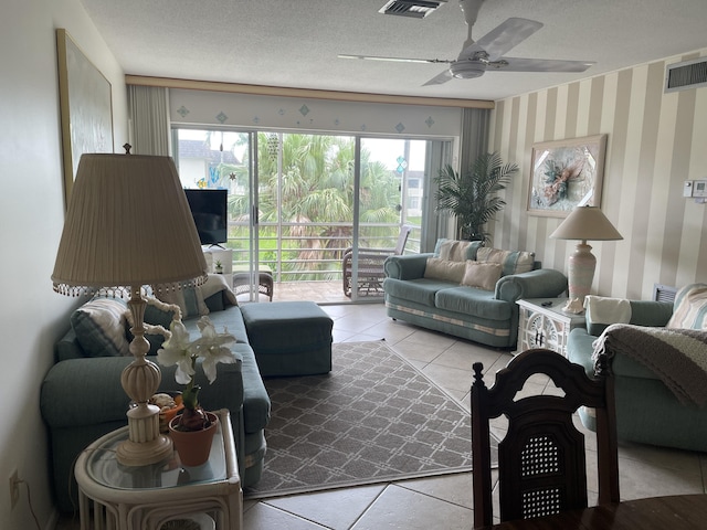 living room with a textured ceiling, a ceiling fan, visible vents, and wallpapered walls