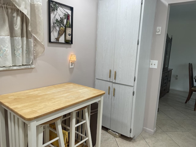 interior space featuring baseboards and light tile patterned floors