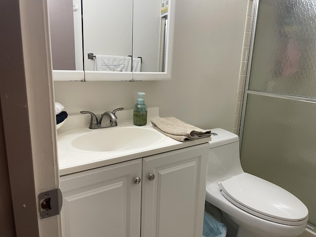 full bath featuring an enclosed shower, vanity, and toilet