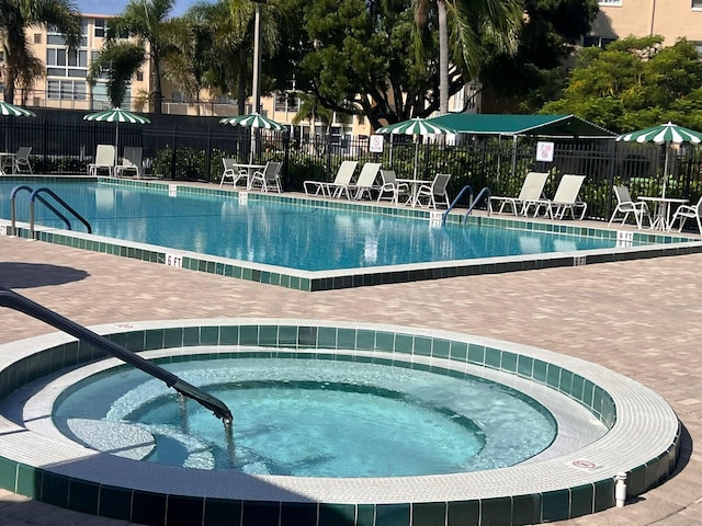 view of pool with a hot tub