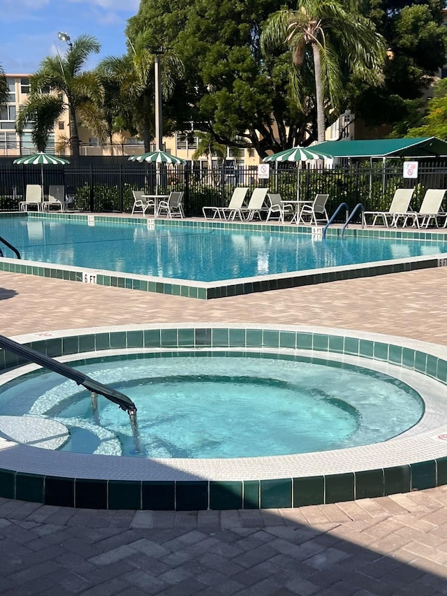 view of swimming pool with a community hot tub