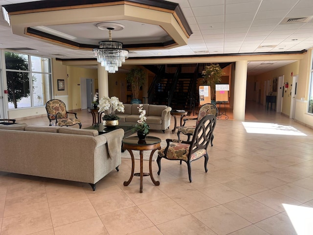 living room with light tile patterned floors, a raised ceiling, and an inviting chandelier