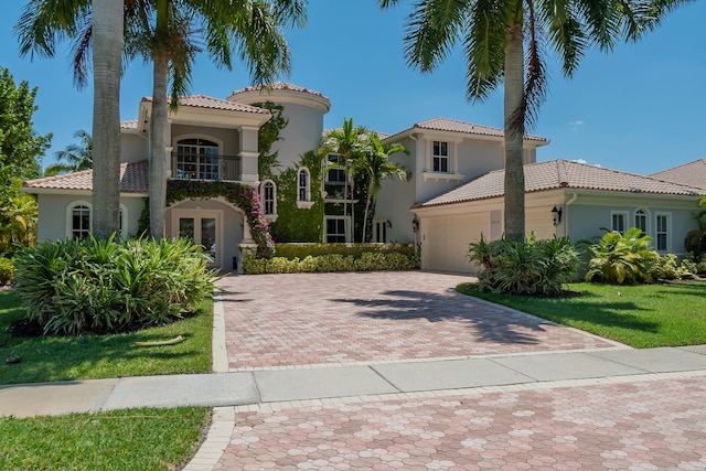 mediterranean / spanish-style house with a balcony and a front lawn