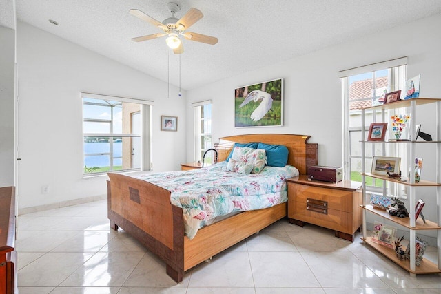 tiled bedroom featuring a textured ceiling, ceiling fan, and lofted ceiling