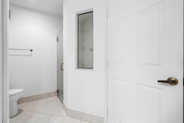 bathroom with tile patterned flooring, an enclosed shower, and toilet