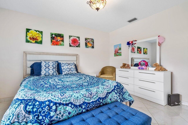 bedroom with a textured ceiling and light tile patterned floors