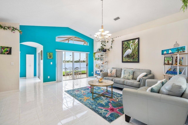 living room featuring a textured ceiling, light tile patterned floors, a chandelier, and a water view