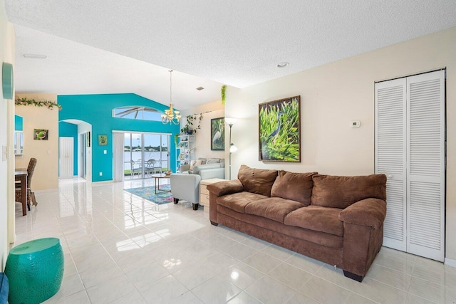 tiled living room featuring a textured ceiling, lofted ceiling, and a chandelier