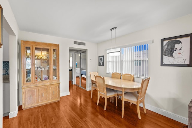 dining space with a healthy amount of sunlight, baseboards, visible vents, and wood finished floors