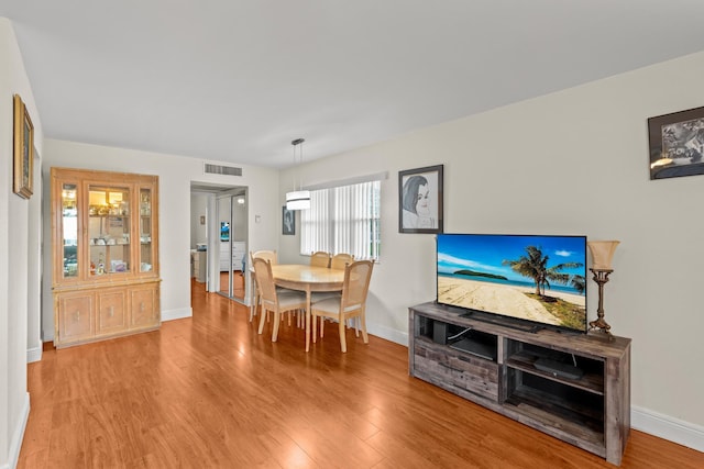 dining room with light wood-style floors, baseboards, and visible vents