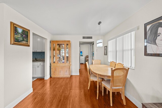 dining area featuring light wood-type flooring, visible vents, plenty of natural light, and baseboards