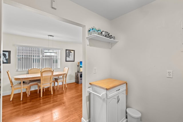 dining space with light wood-style flooring and baseboards