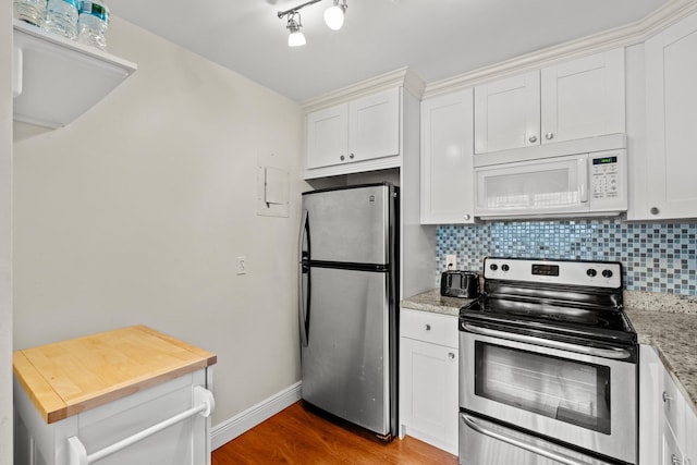 kitchen featuring light stone counters, stainless steel appliances, tasteful backsplash, white cabinetry, and wood finished floors