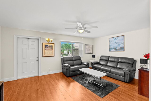 living room with wood finished floors, a ceiling fan, and baseboards