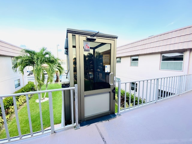 doorway to property with a yard and a balcony