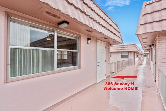 doorway to property with a tile roof and stucco siding