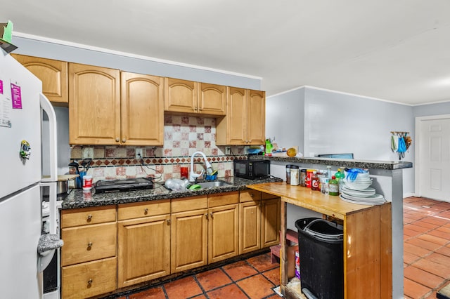 kitchen featuring backsplash, dark tile patterned floors, and white fridge