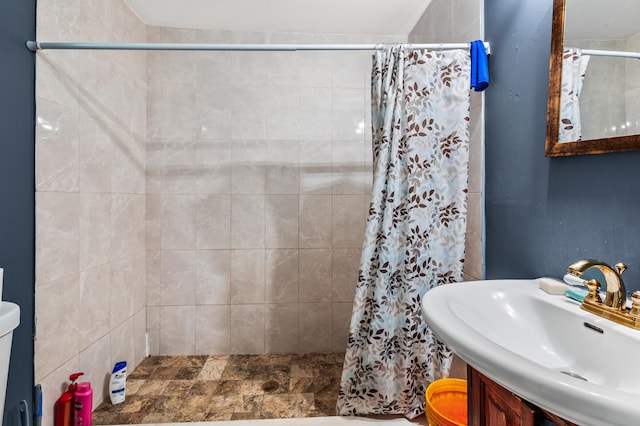 bathroom featuring sink, toilet, and a shower with curtain