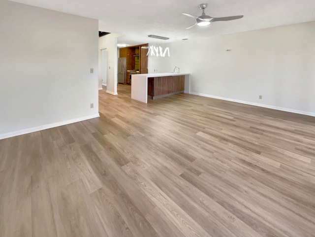 unfurnished living room featuring light hardwood / wood-style flooring and ceiling fan