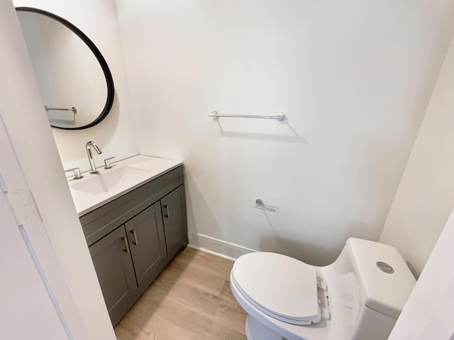 bathroom featuring toilet, vanity, and hardwood / wood-style floors