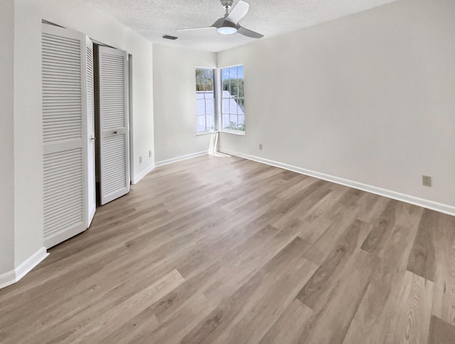 unfurnished bedroom with ceiling fan, light wood-type flooring, and a textured ceiling